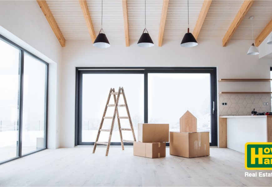 a ladder and moving boxes sitting in an empty room